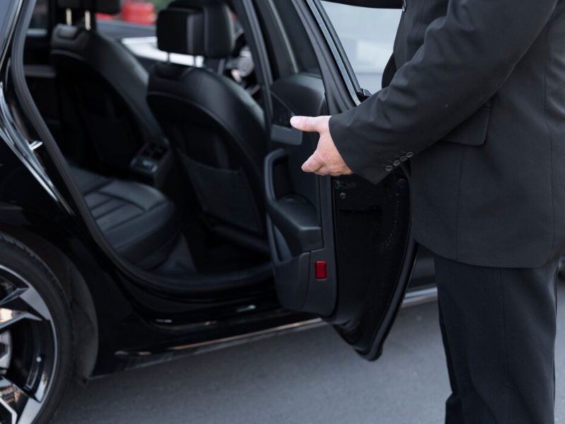 driver-with-opened-car-door_23-2149184241